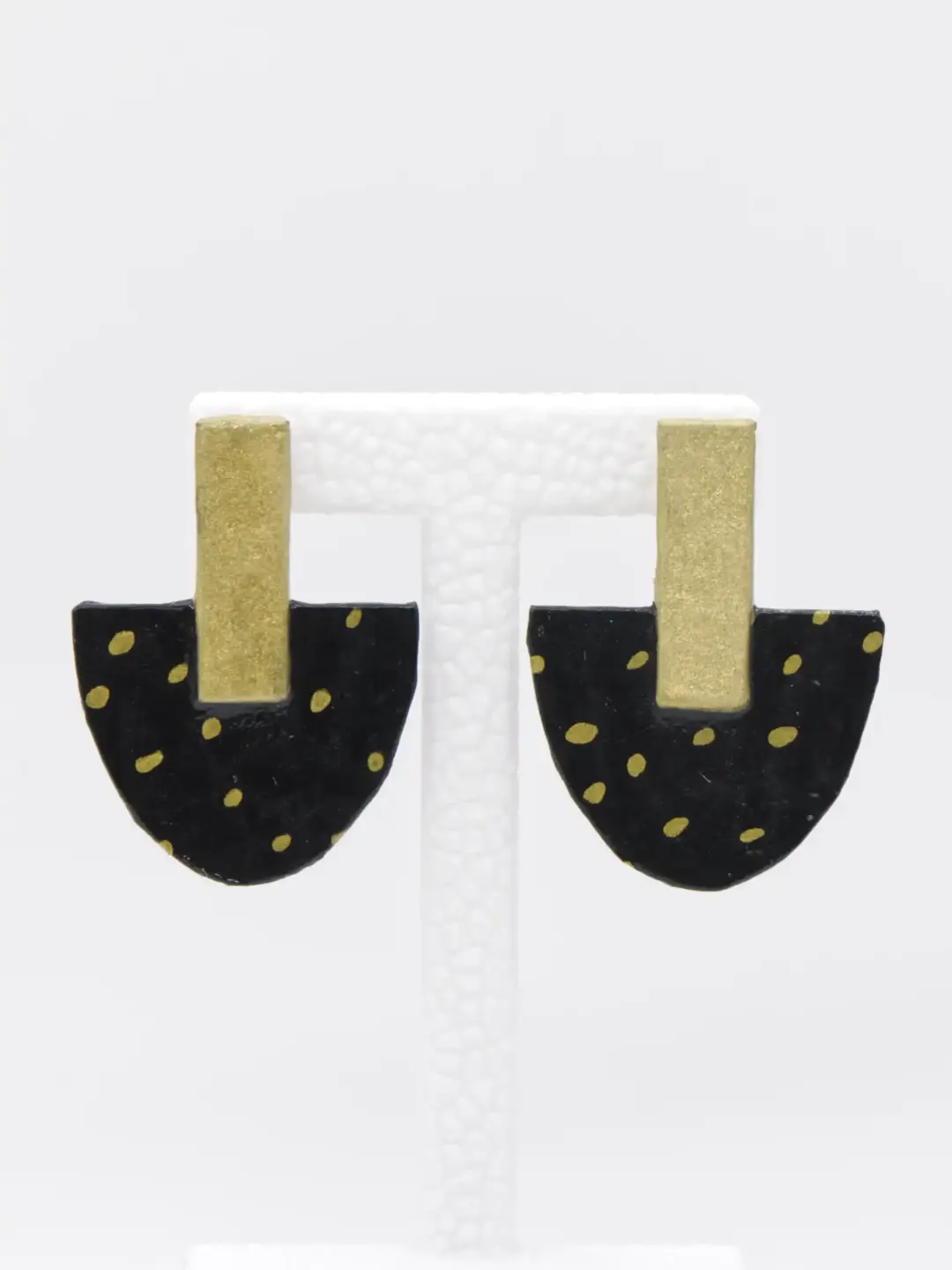 Black half-circle earrings with gold dots and rectangular posts