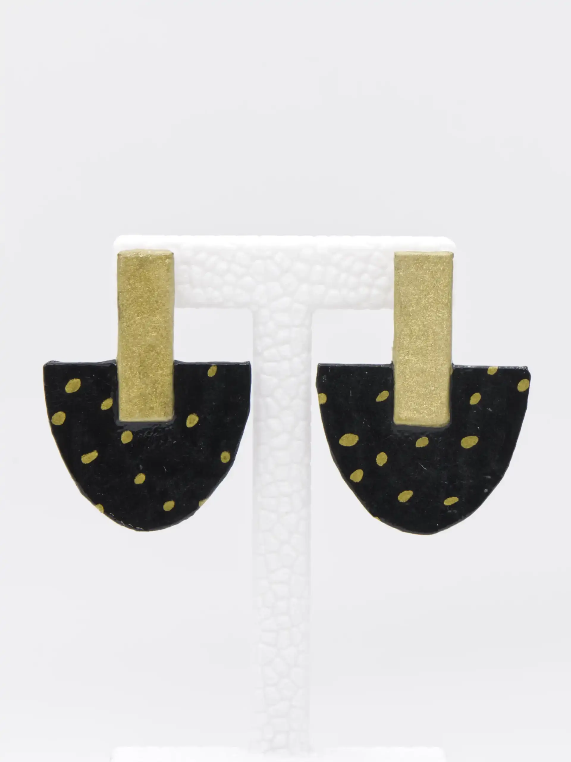 Black half-circle earrings with gold dots and rectangular posts