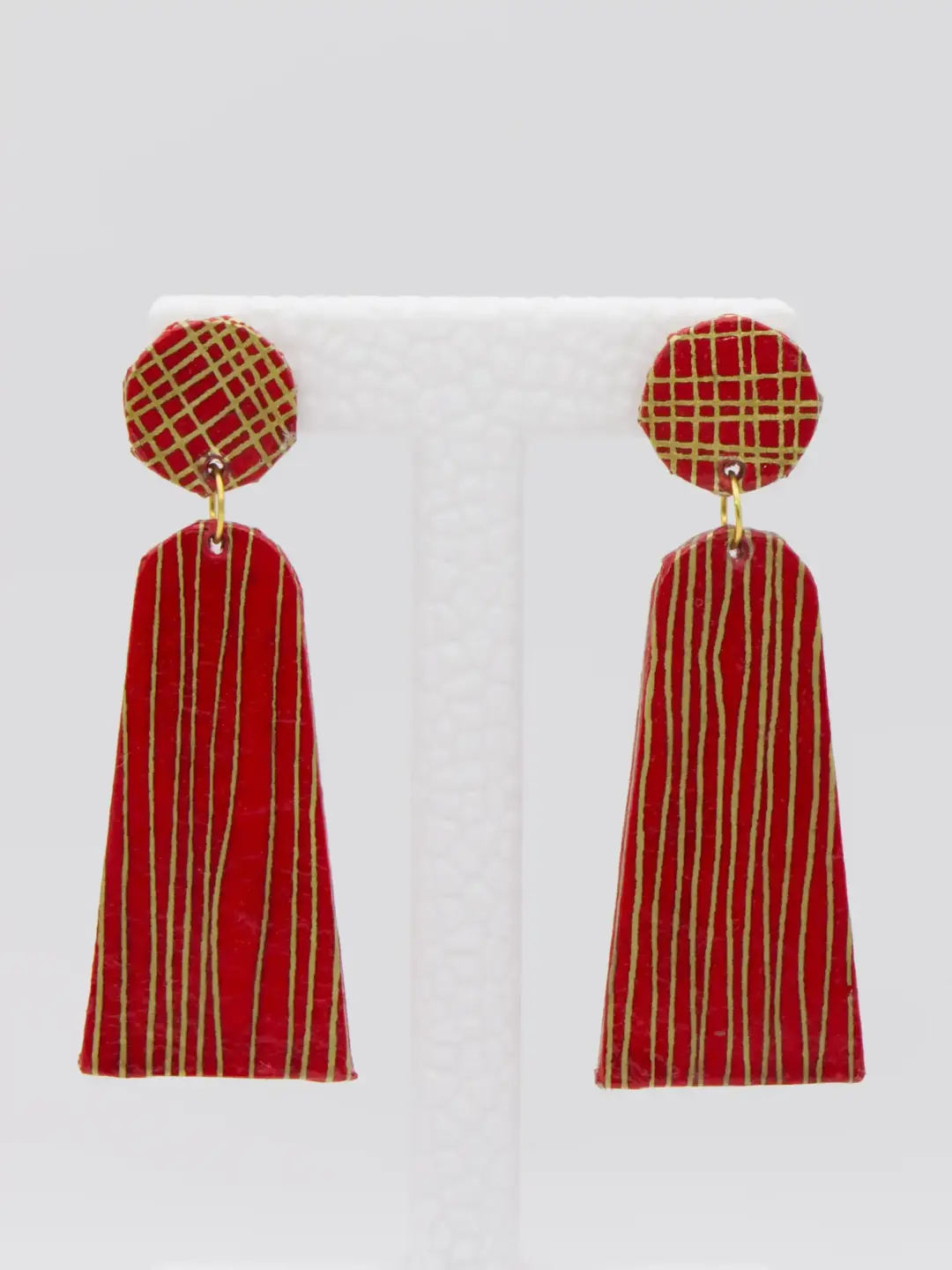 Red and gold patterned tassel earrings on display