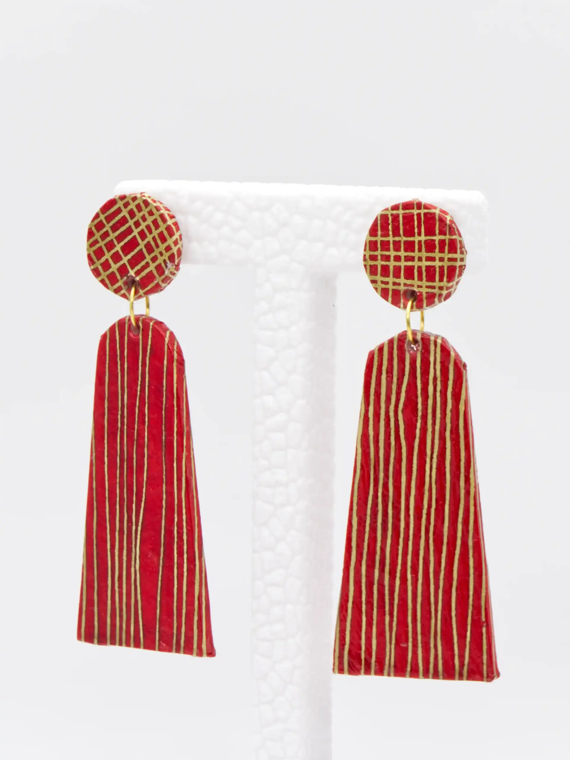 Red and gold striped tassel earrings on display