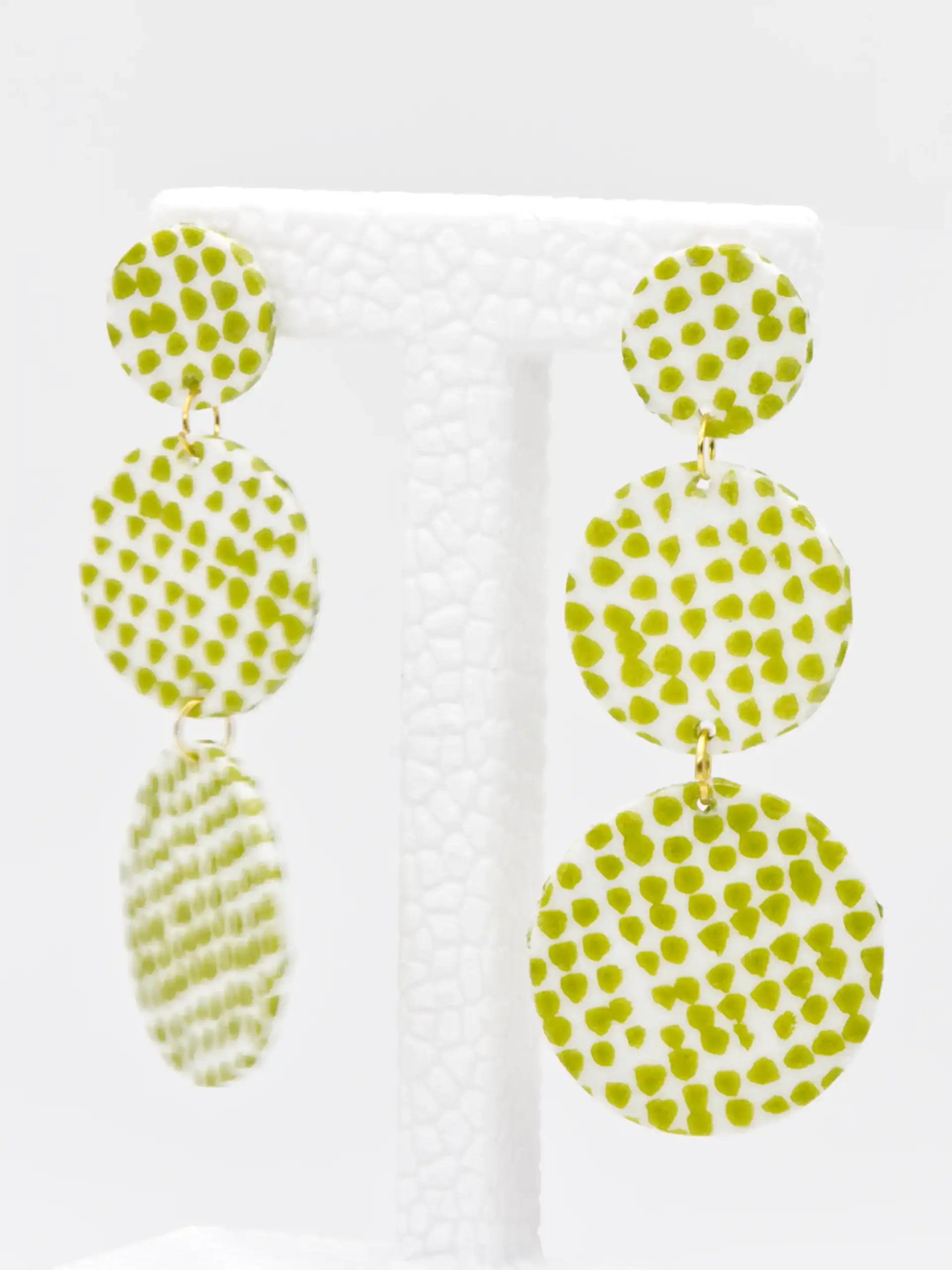 White dangling earrings with green speckles and gold links