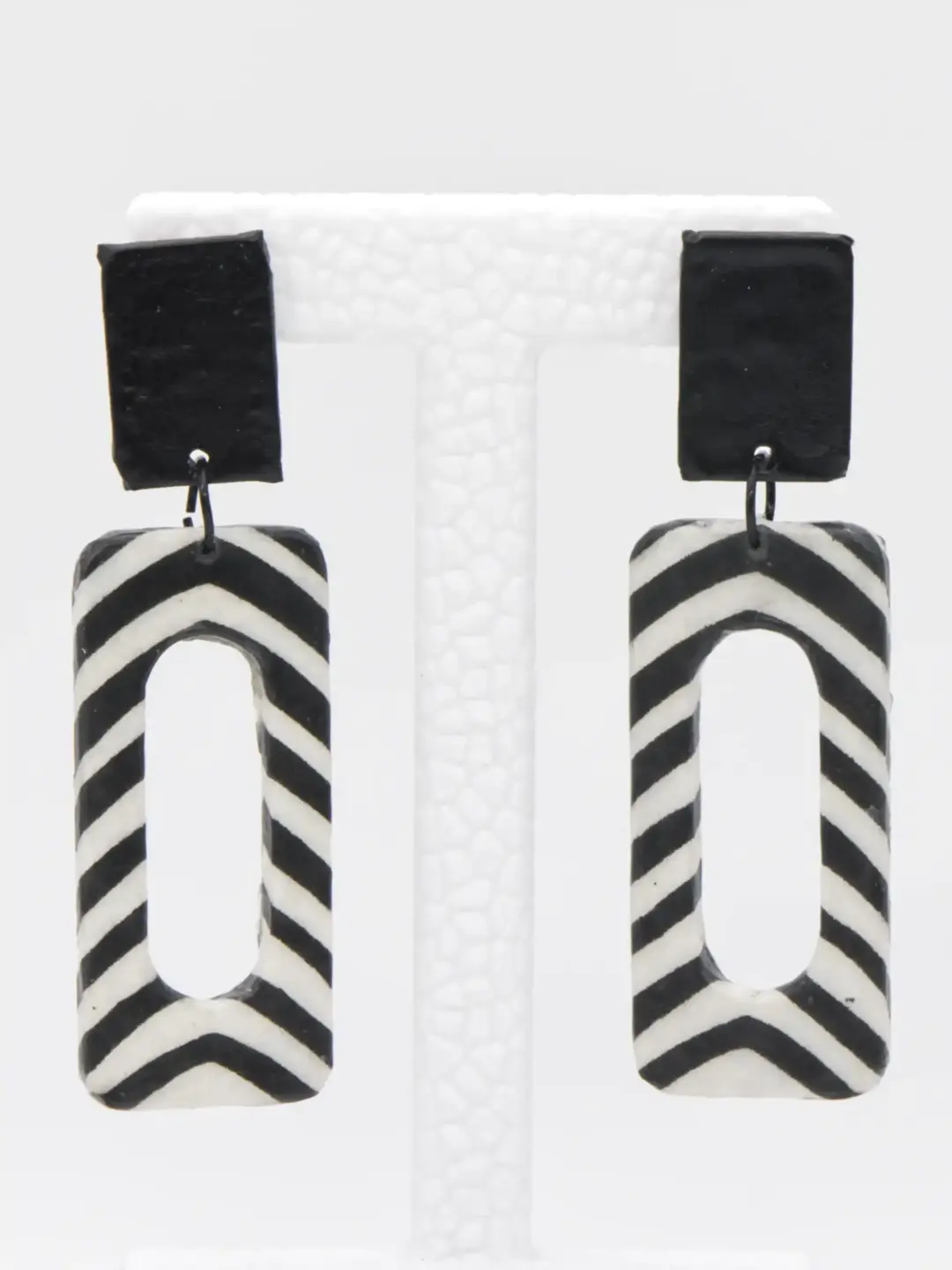 Black-and-white chevron arch earrings on display stand